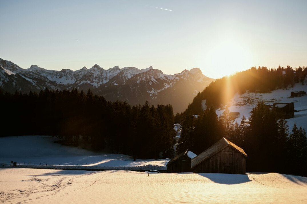 Luxury alpine villa exterior at golden hour in the Swiss mountains